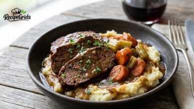 Sliced Braised Mock Chuck over Creamy Mashed Potatoes with Gravy and Carrots.