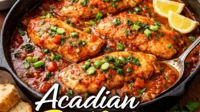 Acadian redfish recipes cooked in Cajun tomato sauce served in a skillet with rice and cornbread