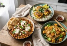 Three healthy and quick recipe jalbiteworldfood meals on a wooden table, including turmeric chicken, lamb skillet, and sesame noodles by RecipeGrids.